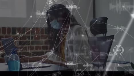 Animation of network of connections over businesswoman wearing face mask in office