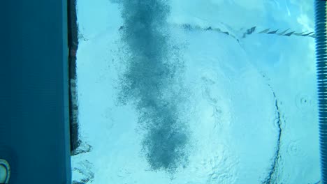 underwater shot of a woman diving into a lap pool wearing professional swimwear