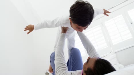 Father-and-son-playing-on-bed