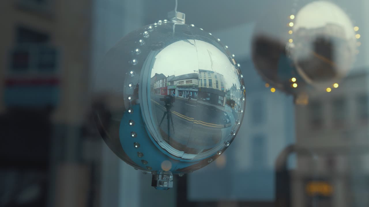 상점 앞 창문에 led 조명이 걸려 있는 크리스마스 트리 볼