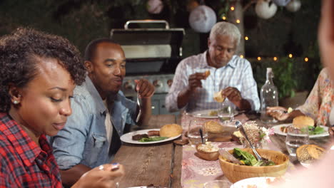 adult black family eating outside at a dinner table