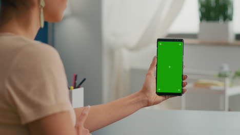 back view of freelencer holding chroma key green screen mock up smartphone