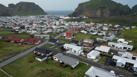 Insular-town-spread-on-remote-island-surrounded-by-volcanic-mountains