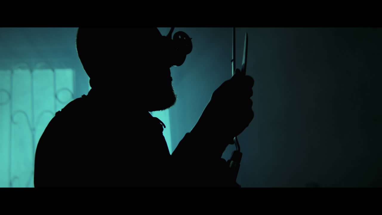 Silhouette of Man with VR Headset and Equipment in a Dark Room