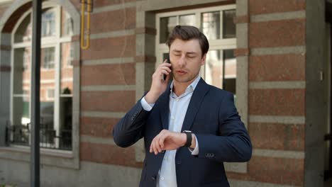 Closeup-businessman-talking-on-phone-at-street.-Man-having-business-talk-outdoor