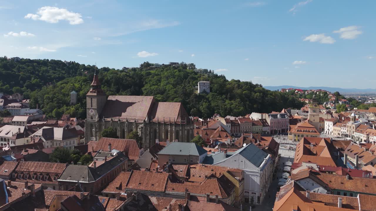 Jævn droneoptagelse, der afslører Den Sorte Kirke fra oven over den gamle bydel og fremhæver middelalderlige gader og arkitektur