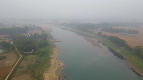 Un-Pequeño-Bote-Al-Lado-De-Un-Pueblo-En-El-Río-Surma-En-Una-Mañana-Nublada