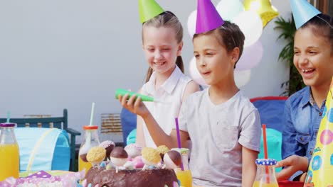 niño tocando el cuerno de la fiesta durante la fiesta de cumpleaños 4k