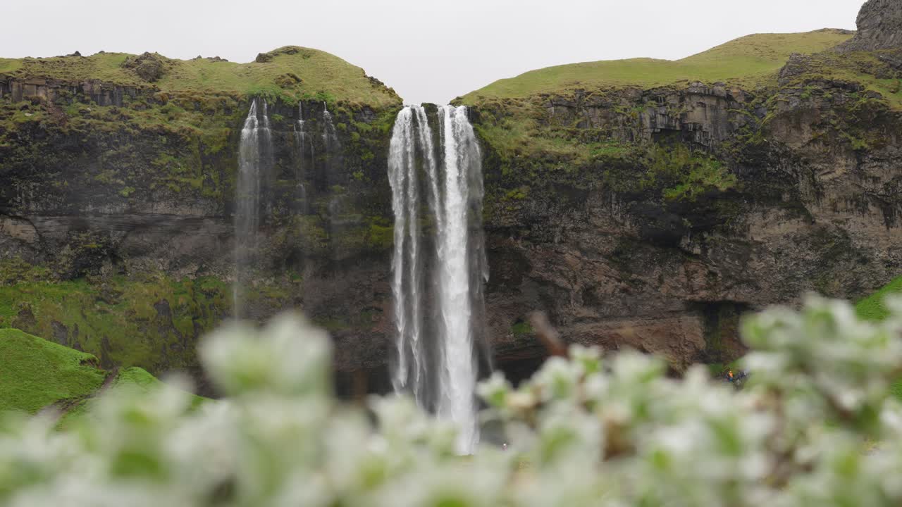 una alta cascada en el sereno paisaje islandés