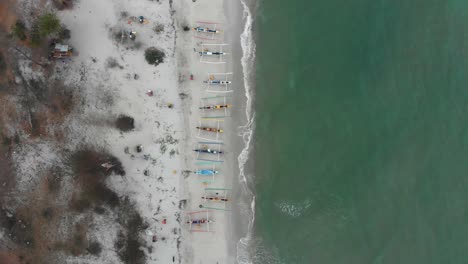 Vista-De-Arriba-Hacia-Abajo-De-Barcos-De-Pesca-De-Colores-En-La-Playa-De-Serdang-Belitung,-Aérea