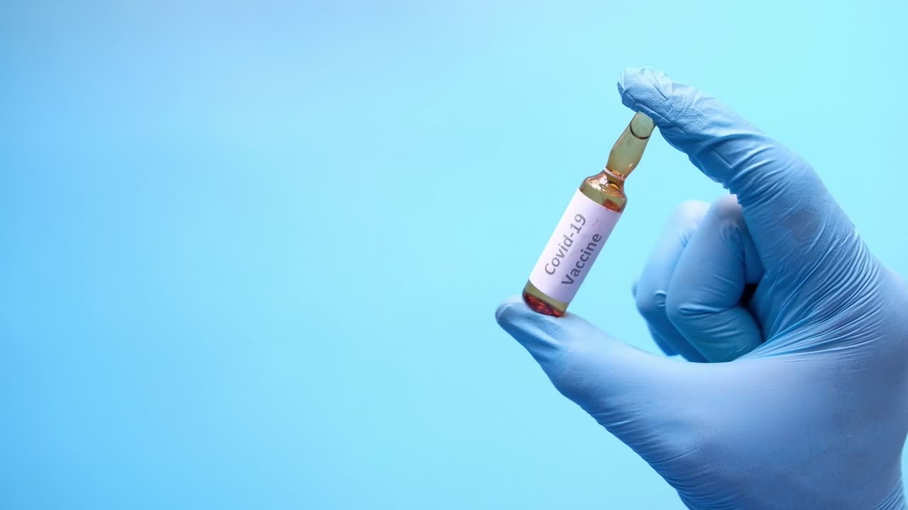 en guante de mano con un vial de la vacuna contra la covid-19