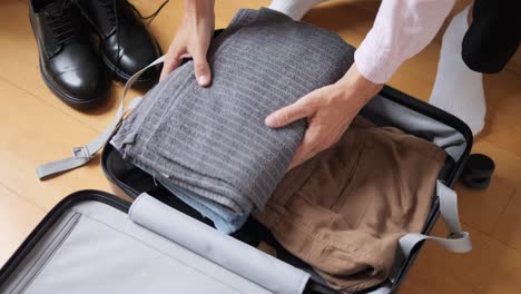 tourism and travelling concept. handsome business man going on holiday, packing his suitcase, checking luggage, sitting on bed and looking at packed things