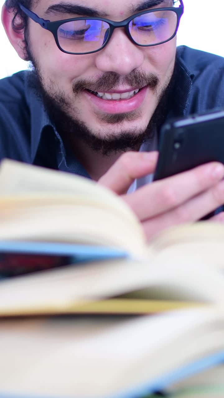 Student Checking Smartphone While Studying with Books