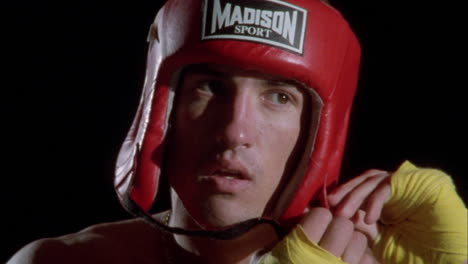 a boxer puts on his helmet