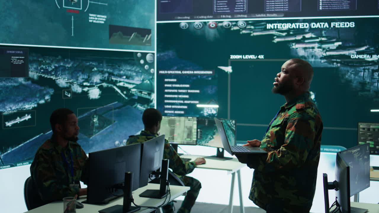 Military specialists work in a high tech command post center
