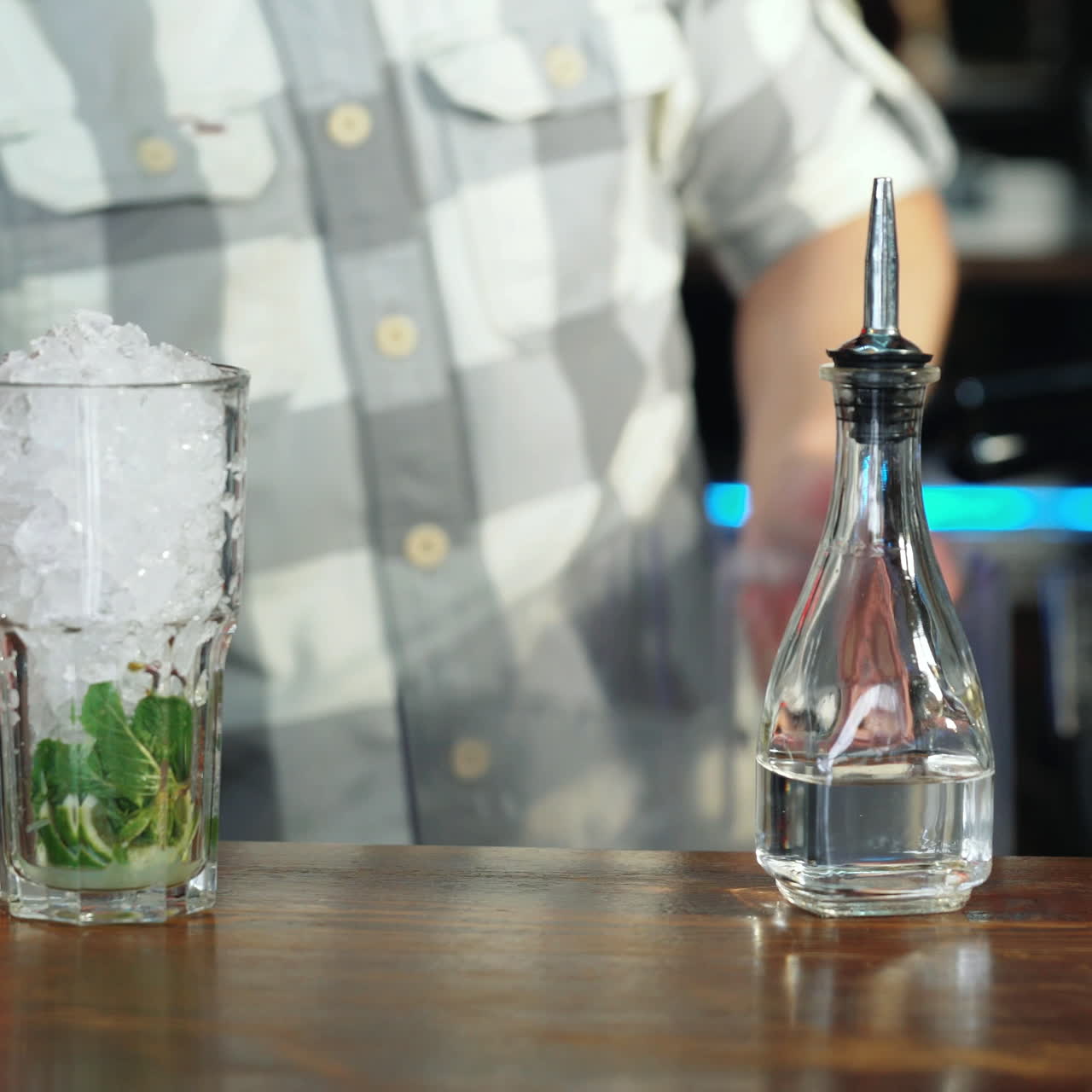 Barman adding an ice into the cocktail glass with a cane sugar and lime for making a delicious cocktail Sqare video
