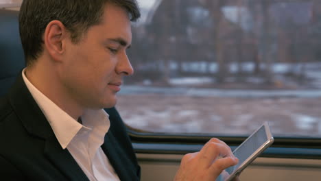 businessman traveling by train with tablet pc