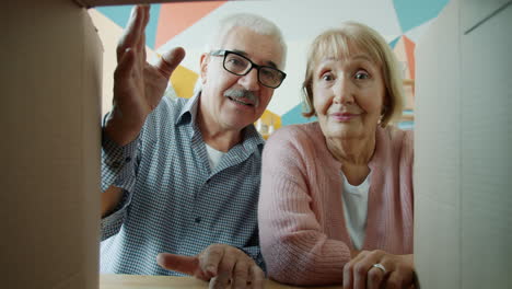 elderly couple excitedly unboxing a gift
