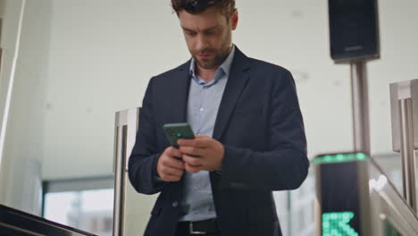 director passing office security swiping card looking smartphone. busy manager