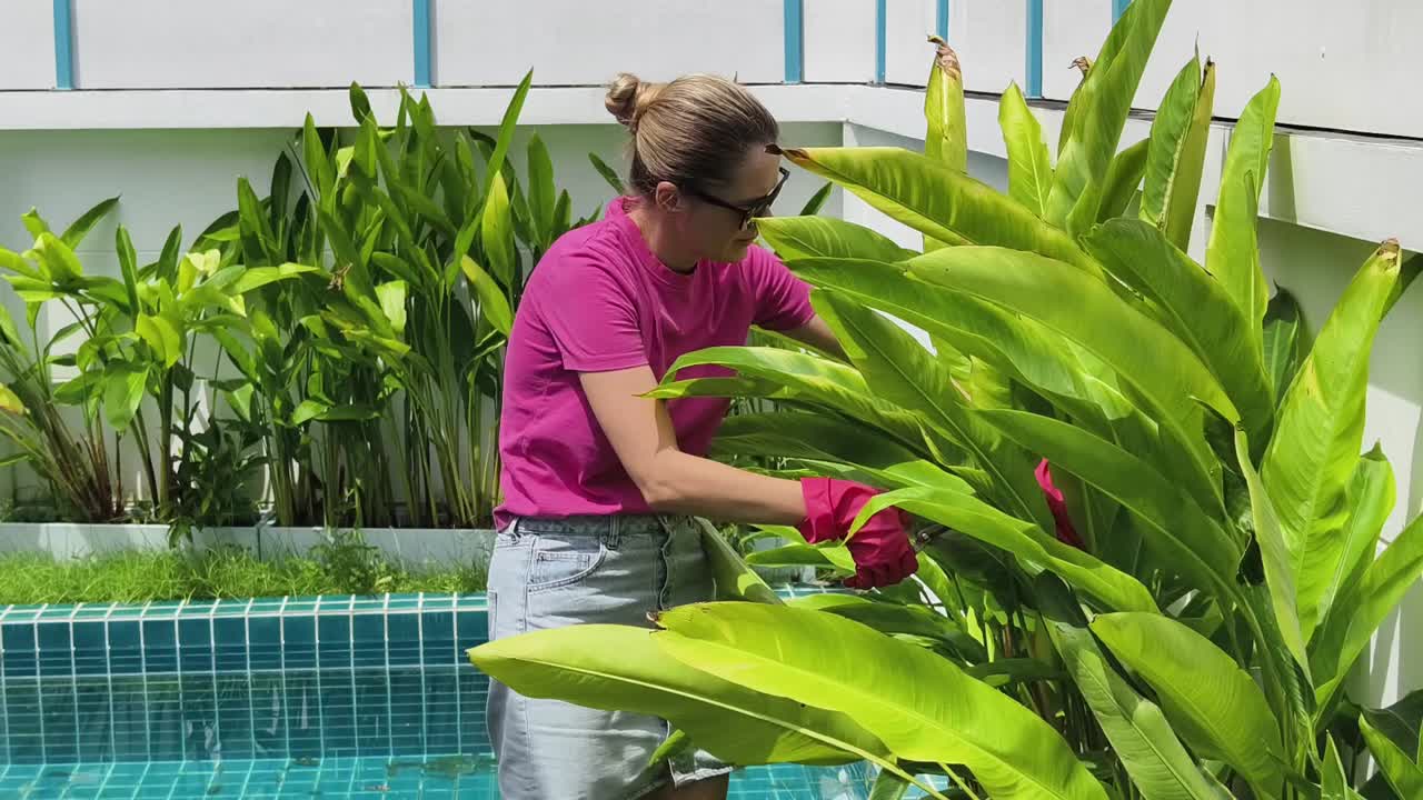 mujer jardinería junto a la piscina