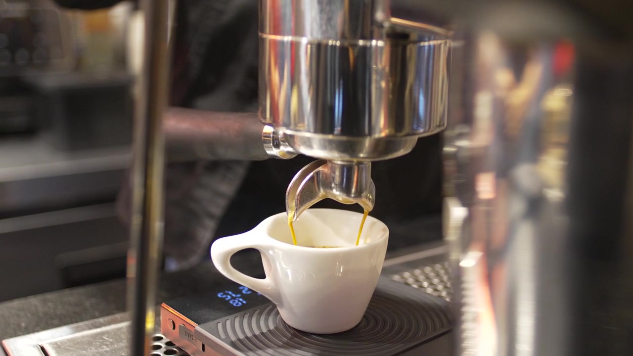 Estrazione di espresso a tostatura scura con crema dorata al bancone di un bar professionale, caffè specialty