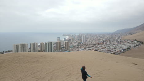 Toma-Aérea-De-Un-Turista-Tomando-Un-Video-Para-Llegar-A-La-Cima-De-La-Famosa-Duna-Del-Dragón-Cerra-En-Tarapaca,-Iquique-Chile-Latinoamérica