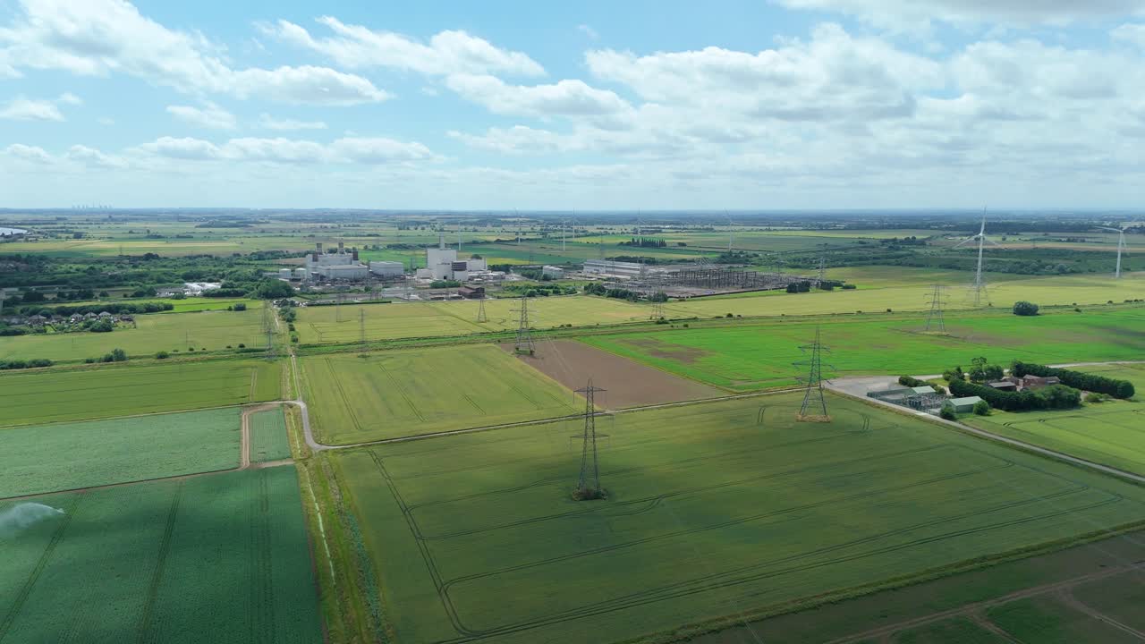 Drone shot of Keadby power plant, rural agriculture landscape with powerlines crossing fields Lincolnshire England UK