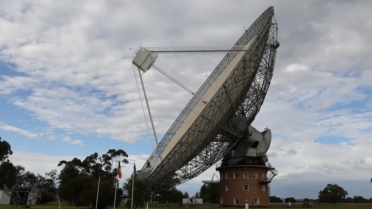 구름이 가득한 하늘 아래 회전 하는 큰 라디오 망원경 접시
