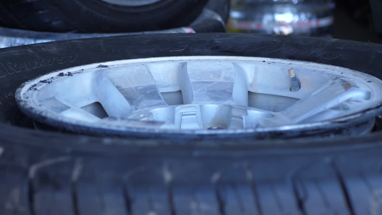 Close Up Shot Of Spinning Car Tyre Being Removed From Rim Manually