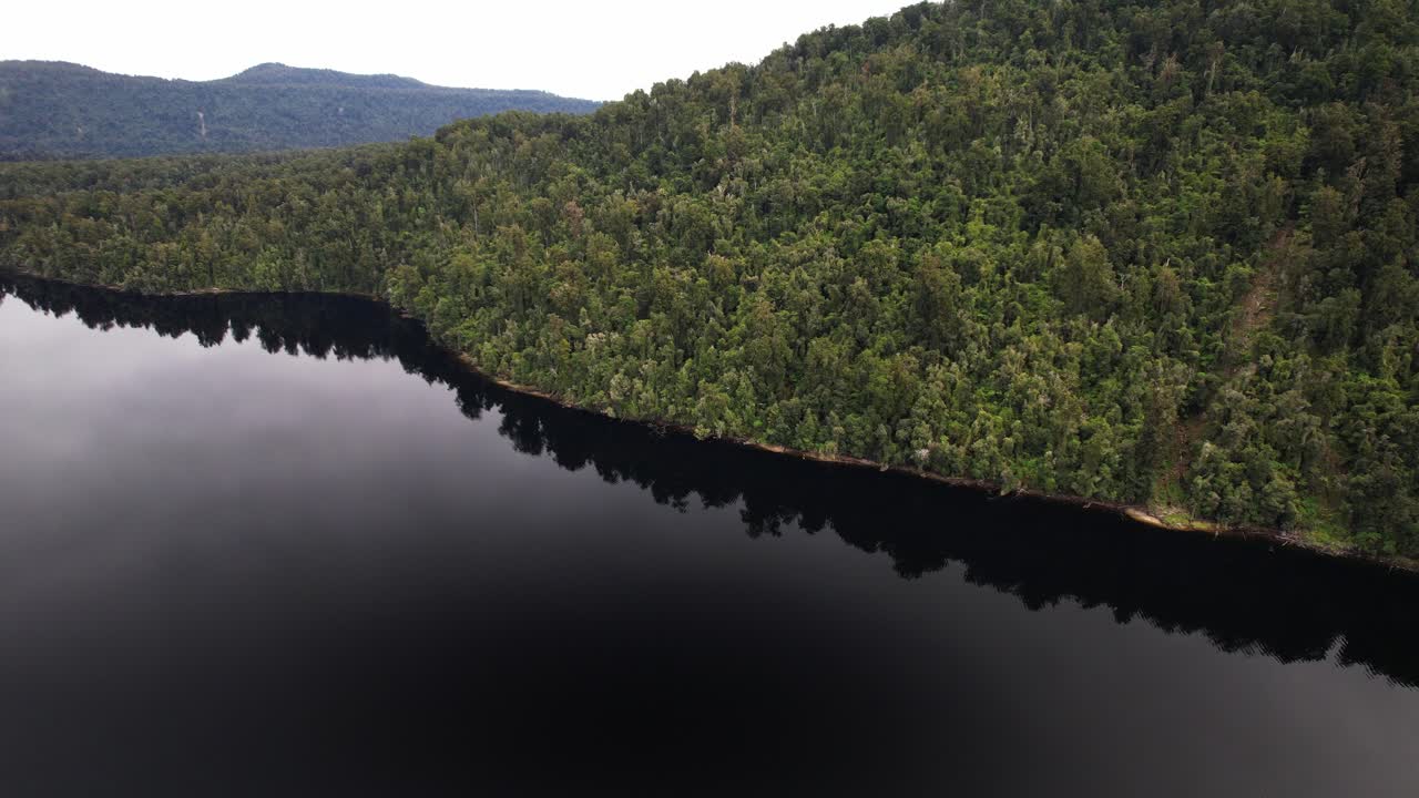 Tranquil Water Of Lake Mapourika With Dense Forest In West Coast, New Zealand. - aerial shot