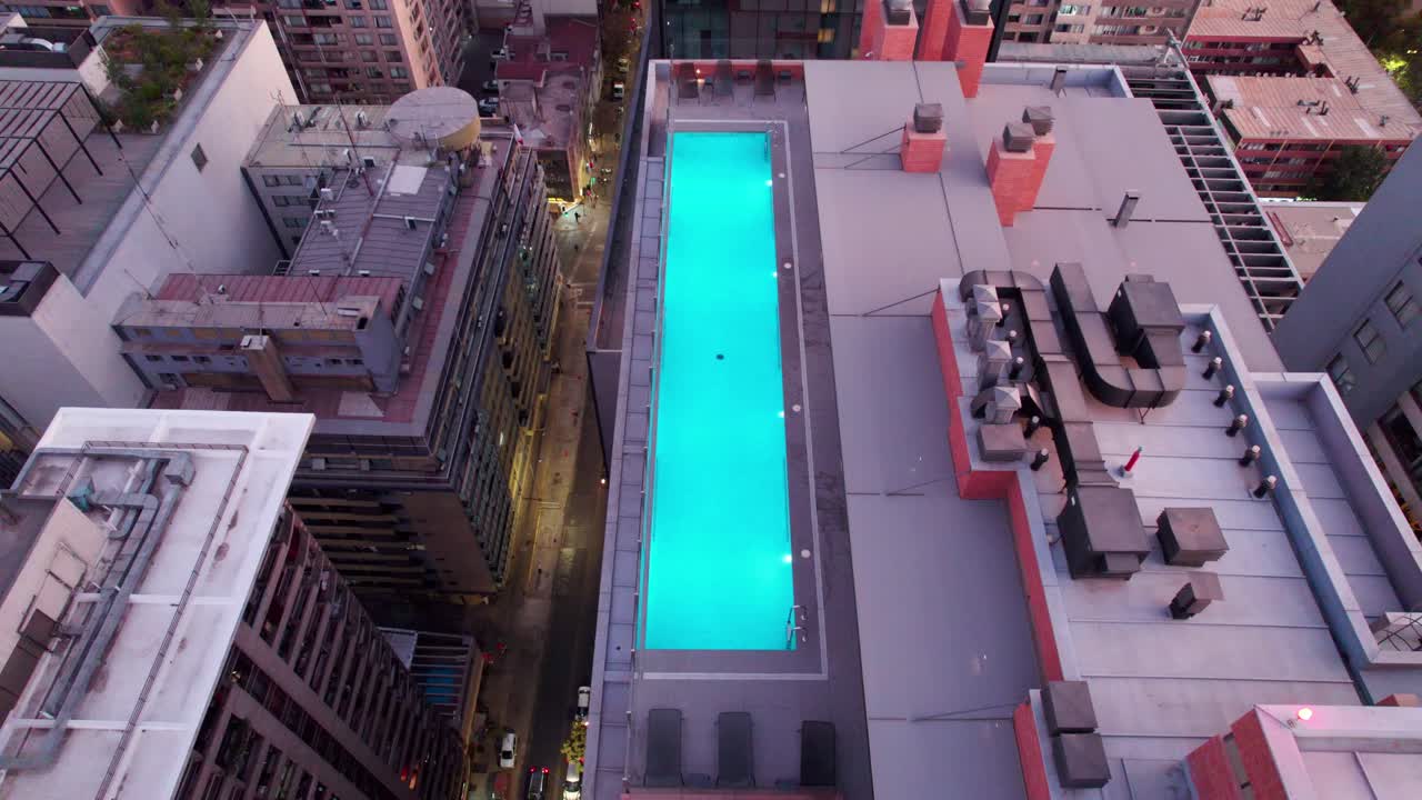 vista aérea de una piscina en la azotea de un lujoso edificio en la ciudad de santiago