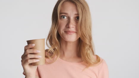 caucasian woman drinking water and laughing on camera.