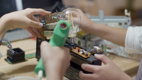 closeup shot of two children constructing electrical mechanism