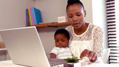 mamá seria con bebé trabajando