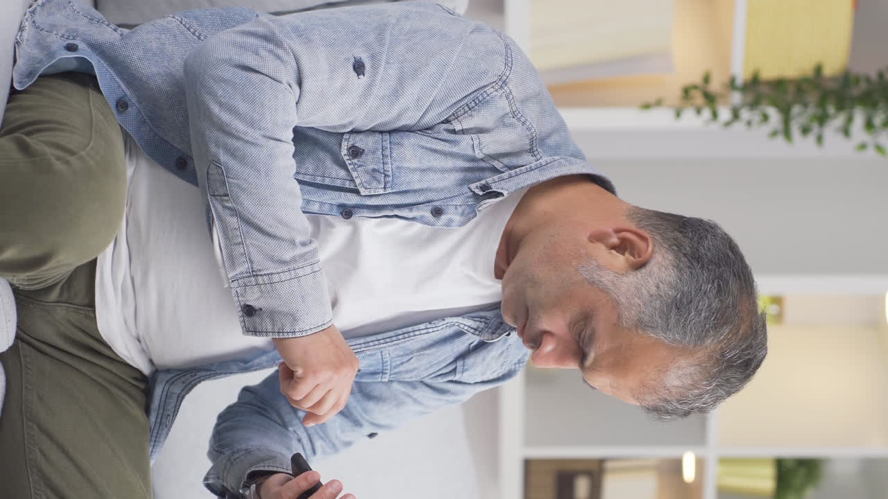 Vertical video of The man who gets angry and upset at the incoming phone message.