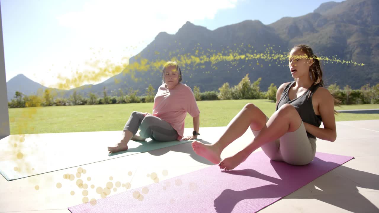 Mom-daughter doing seated yoga, breathing, twisting, knee lifting, sparkling over them for wellness