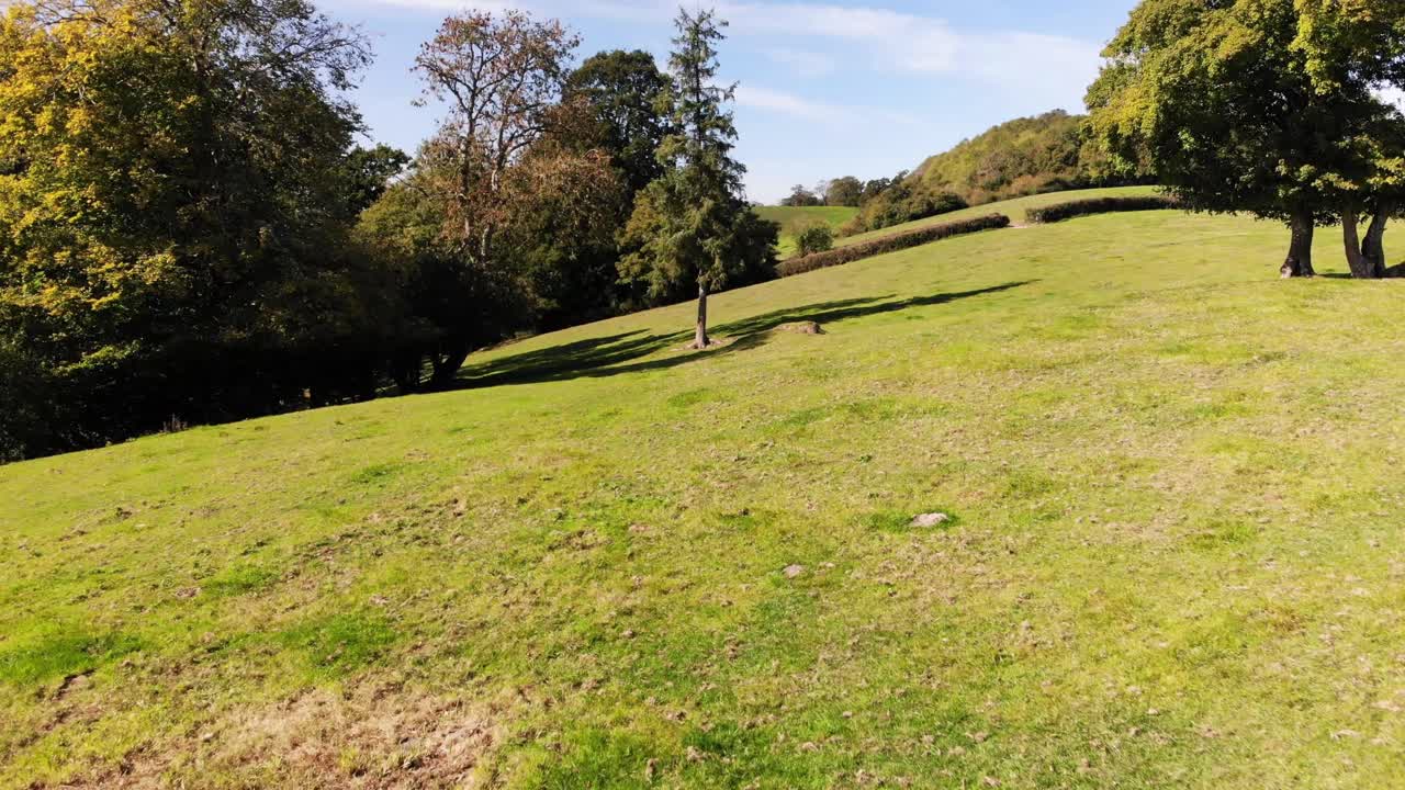 воздушный низколетящий снимок парковой зоны и холмов в девоне англия