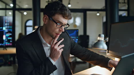 Finance-broker-working-late-in-lamp-light.-Serious-businessman-check-computer