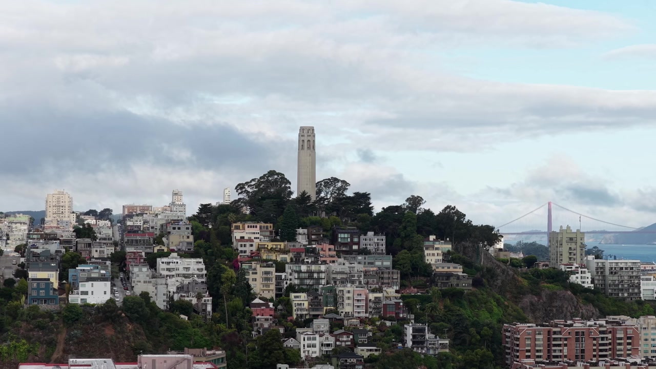 Torre Coit en Telegraph Hill en una mañana espectacular en San Francisco, California. Puente Golden Gate al fondo. Toma lateral con dron.