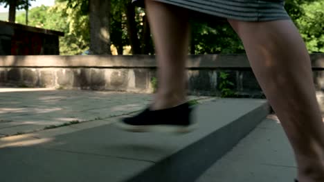 young attractive muslim girl in hijab walks up stairs in park in daytime in summer, smiling, crossing street, religious concept, urban concept, side view