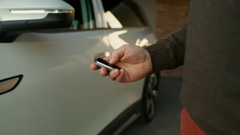 hombre usando el control remoto del coche para abrir la puerta del coche