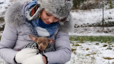 woman playing with her little dog outside winter