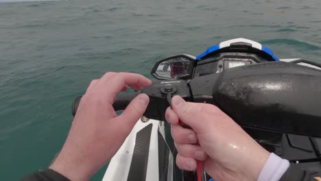 pov shot of a rider attaching his kill switch and starting the jet ski to drive