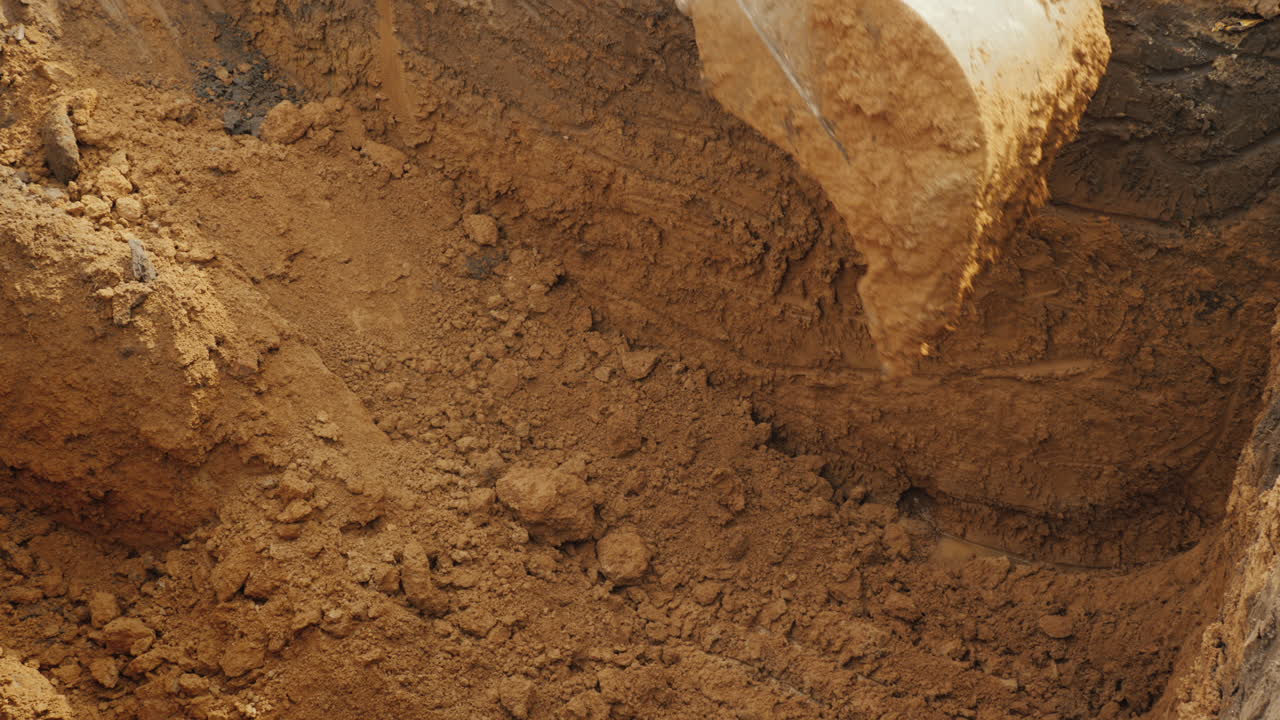 cuchara excavadora extrae tierra del trabajo de excavación de trincheras en el sitio de construcción