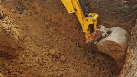 Excavator-Bucket-Extracts-Ground-From-Trench-Excavation-Work-At-The-Construction-Site