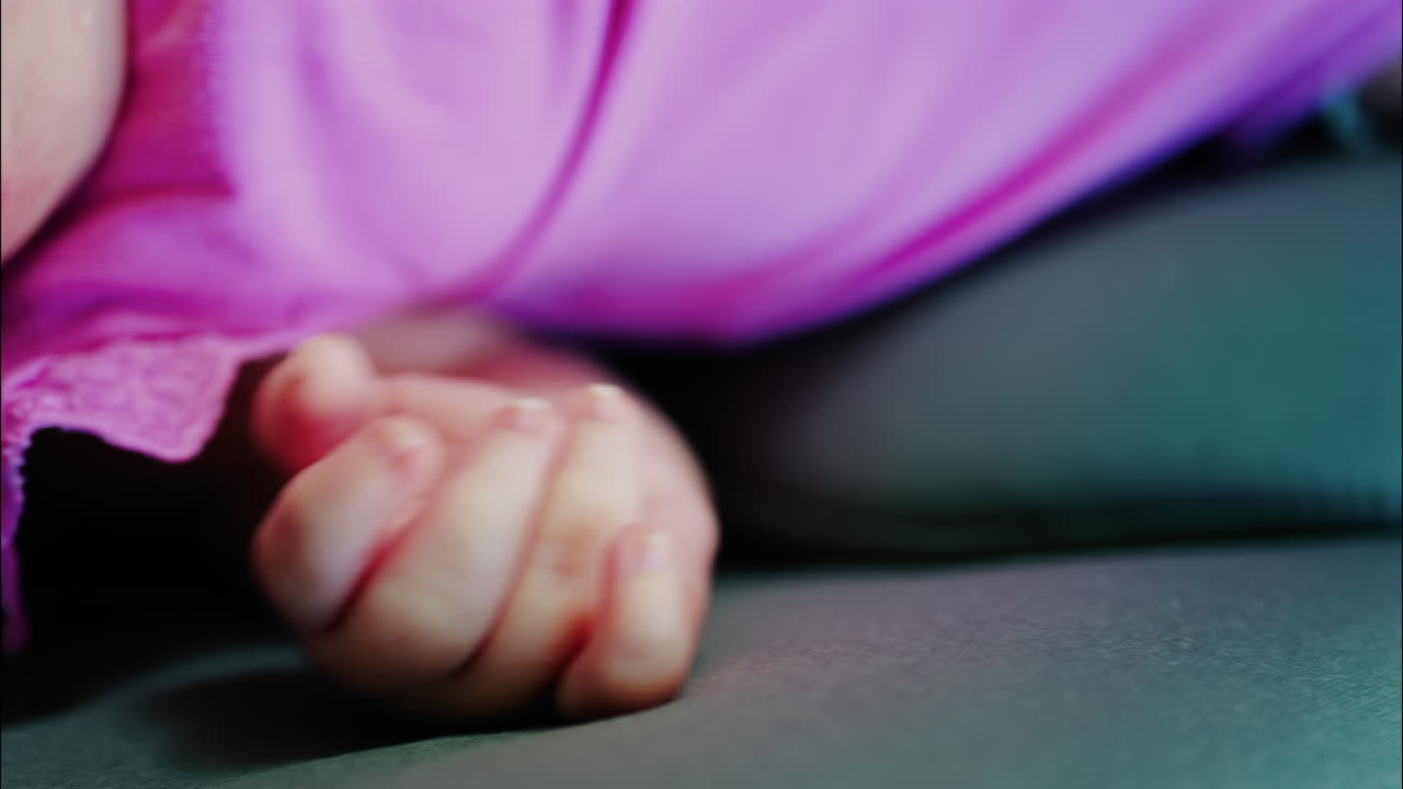 Close up view of a baby's hand and fingers curled in a natural pose while resting