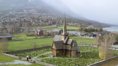 Lom-Stave-Church-And-Graveyard-In-Lom,-Norway-During-Snowstorm-Weather