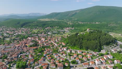 Vuelo-Aéreo-Sobre-La-Hermosa-Ciudad-Verde-De-Sinj-En-Croacia-En-Un-Día-Soleado-De-Verano