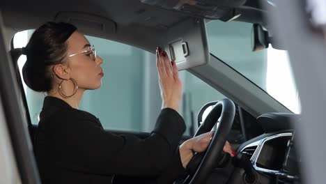 young woman inside a car dealing with various distractions like looking at her phone rear view. a young woman inside a car is multitasking dangerously, glancing at her phone, applying lipstick, talking on the phone, and checking the rear view mirror, creating a chaotic and risky situation
