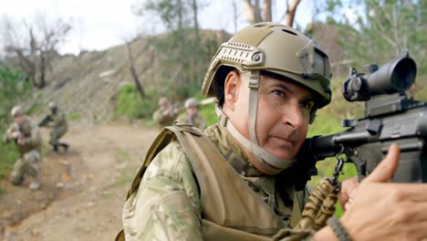 Front-view-of-mid-adult-caucasian-military-soldier-showing-hand-signal-on-field-during-training-4k